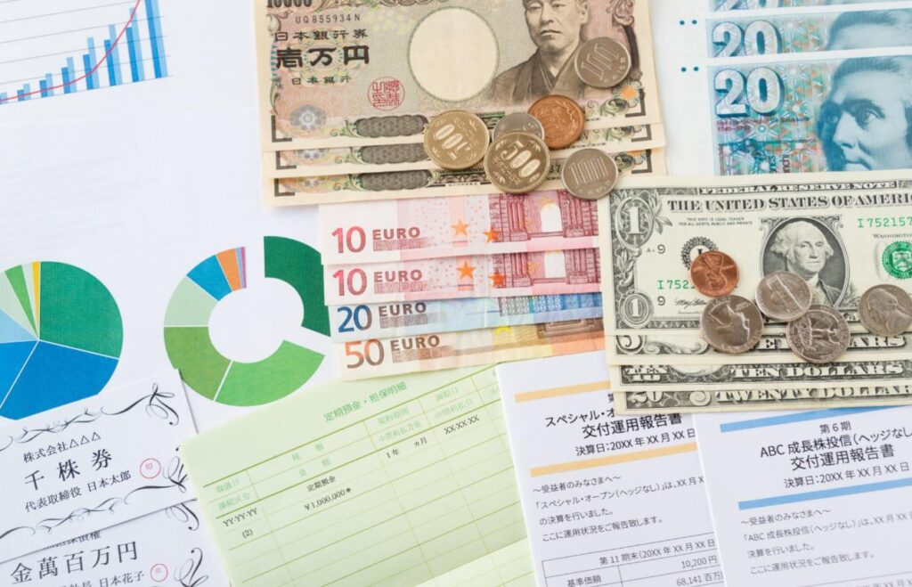 Assorted international currencies (yen, euro, dollar) with charts and financial documents collage for finance context