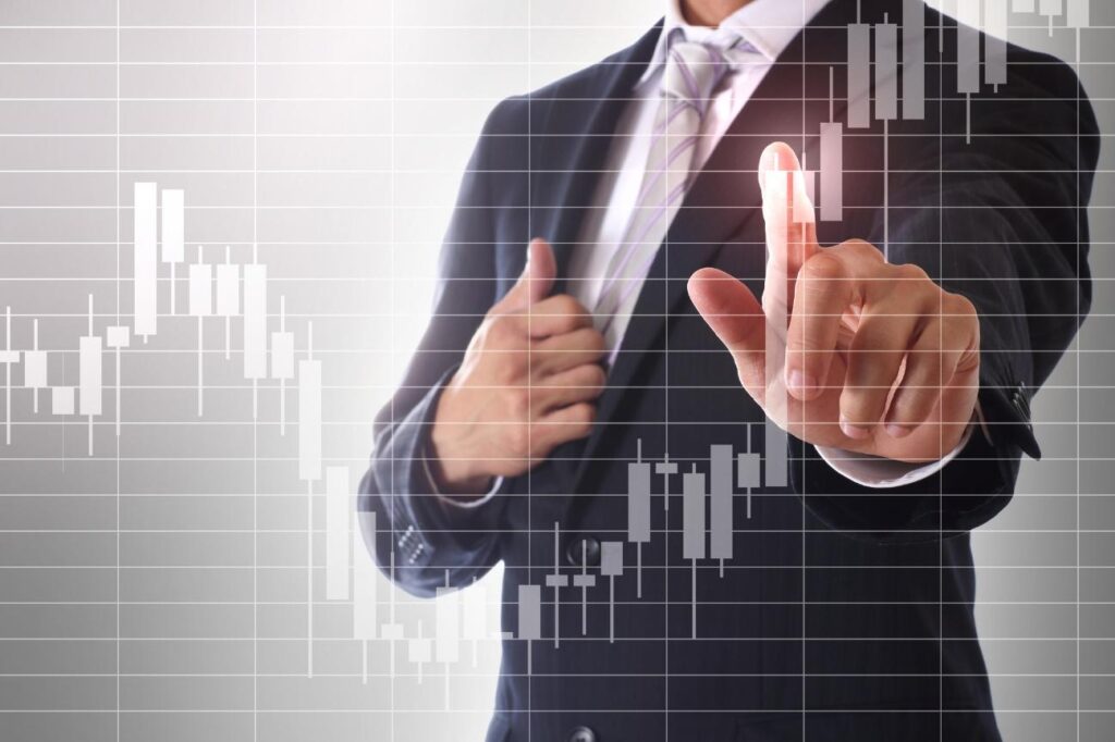 Businessperson in a suit points at a transparent stock chart overlay, illustrating market analysis.